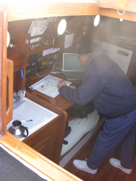 Steven Charting the AM approach in San Diego Bay on the laptop using paper charts and checking MacENC on the Mac. I was very proud that the nav table I designed actually functioned!!!  You can lean heavily into when the goin gets rough and it supports you. It folds down to go behind the settee cushions when not in use.
